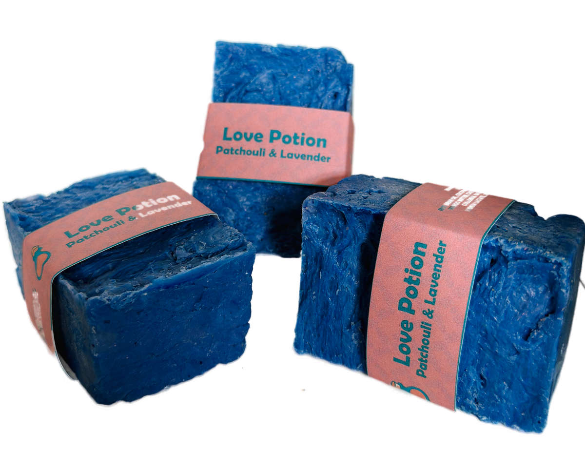Three bars of Love Potion Patchouli and Lavender handmade soap by Bouncing Studio with blue color and pink label on white background