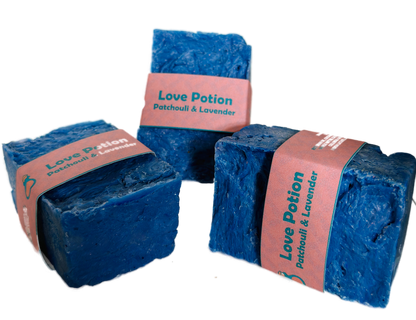 Three bars of Love Potion Patchouli and Lavender handmade soap by Bouncing Studio with blue color and pink label on white background
