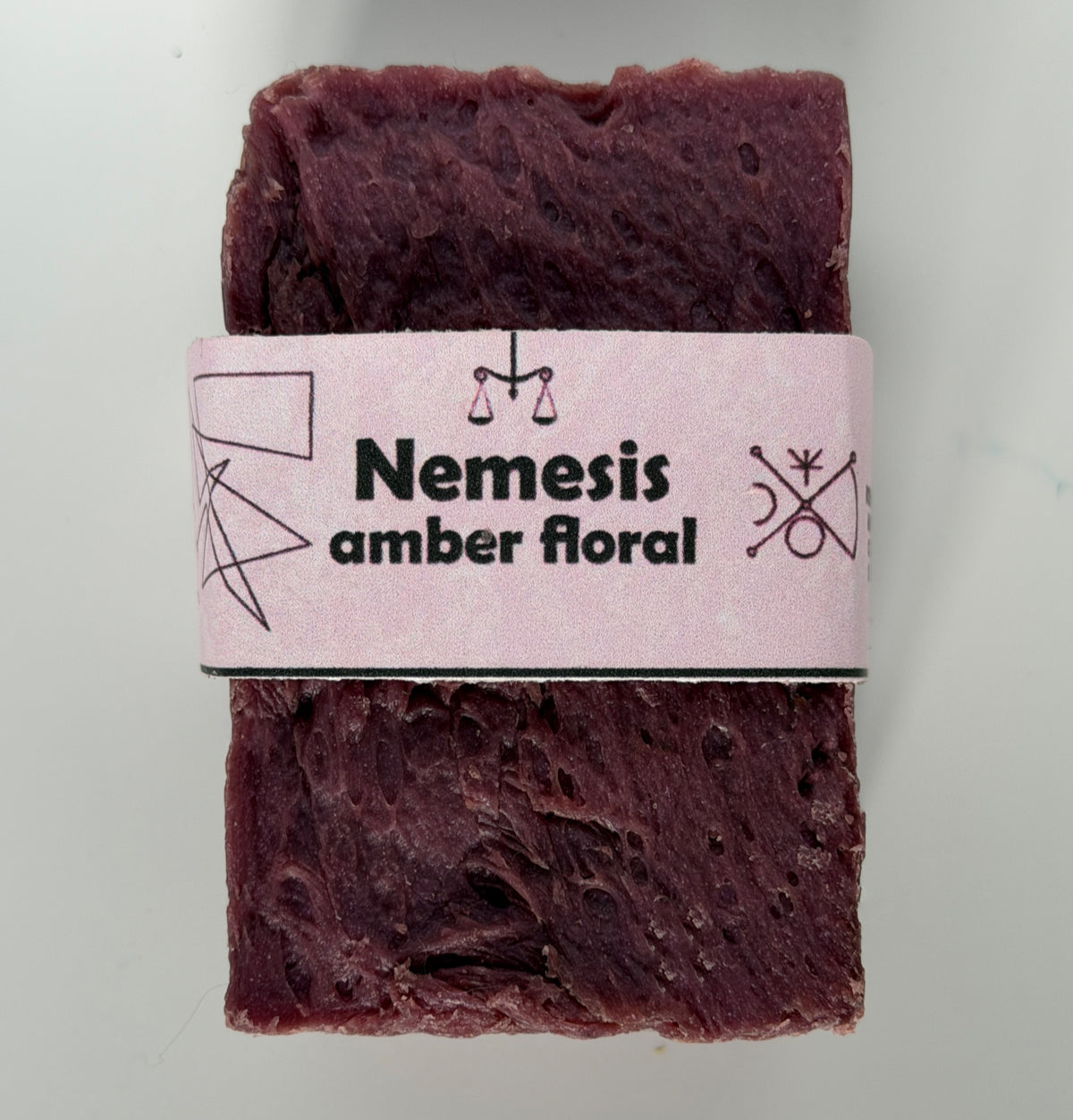 Coral-rose handmade soap bar with swirled rustic texture, wrapped in a vintage carnival-style yellow and cream band reading "Shiny Boy – Tropical Gourmand"